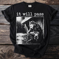 Black t-shirt with white graphic of a wolf-like creature squatting in the rain with text "it will pass".
