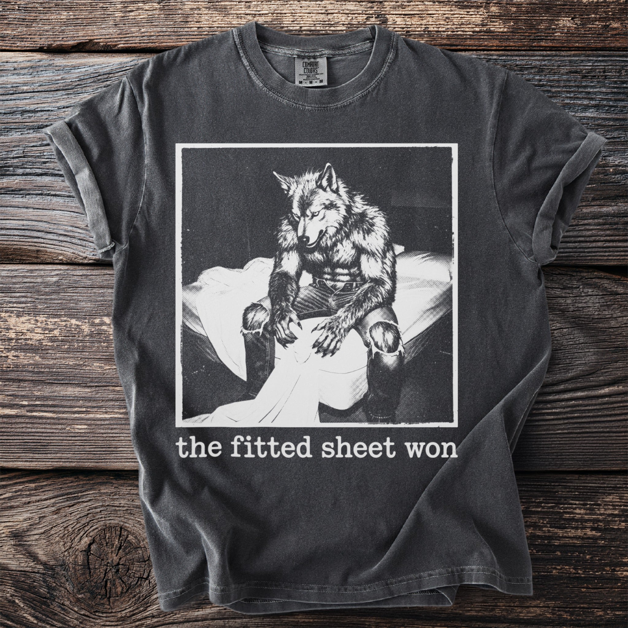 T-shirt with distressed print of a werewolf sitting on a bed, text reads "the fitted sheet won."