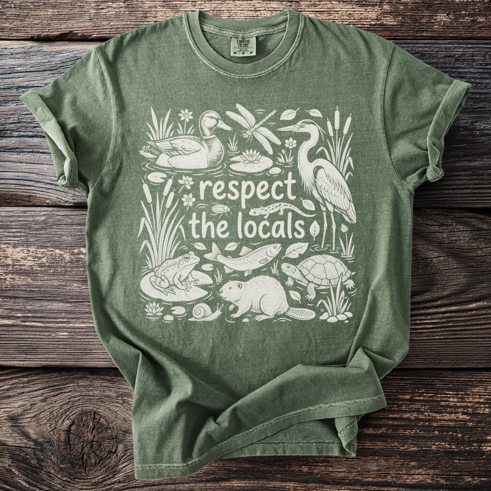 Green t-shirt with white graphic of marsh animals and text "respect the locals".