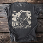 Dark t-shirt with graphic of a knight kneeling with a sword on a rocky landscape.