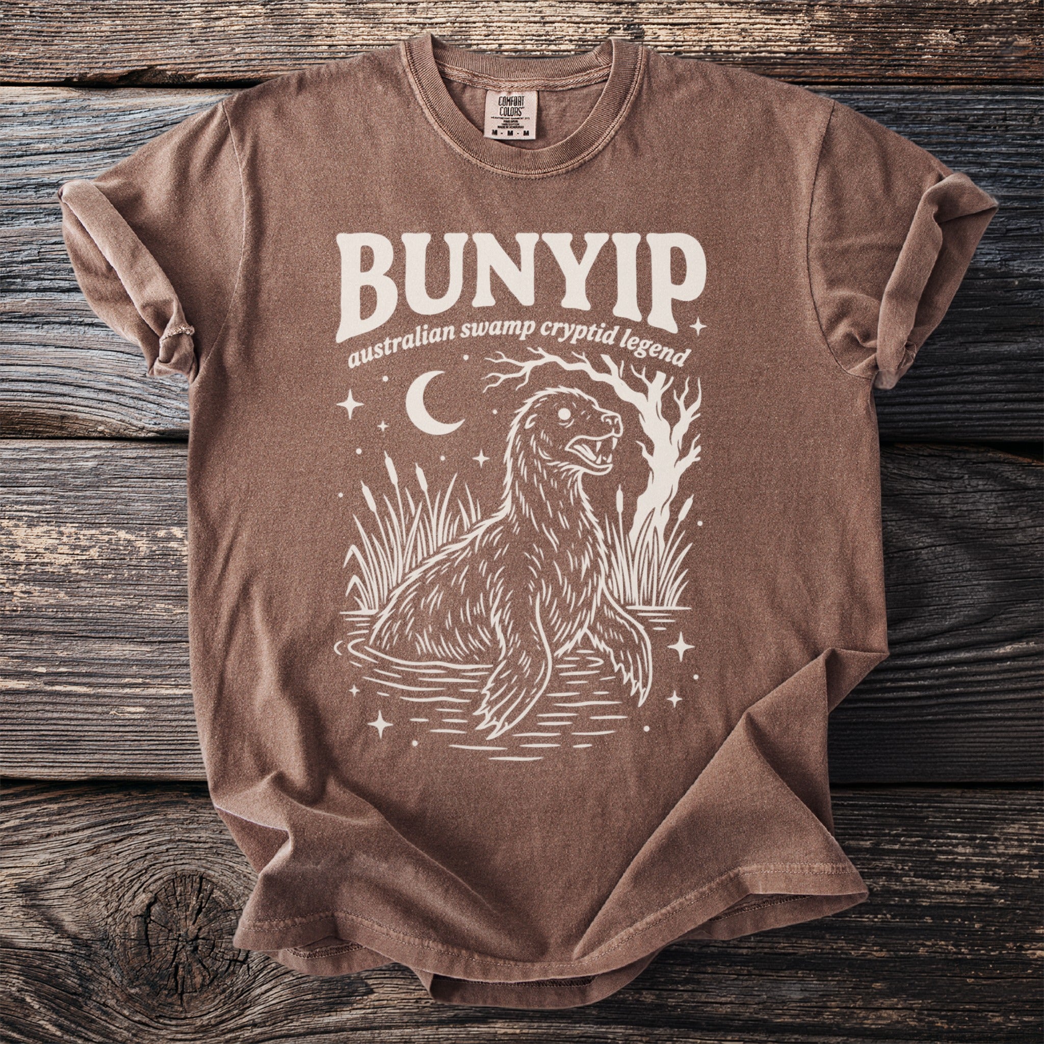 Bunyip Australian Swamp Cryptid Legend graphic t-shirt with moon and stars.