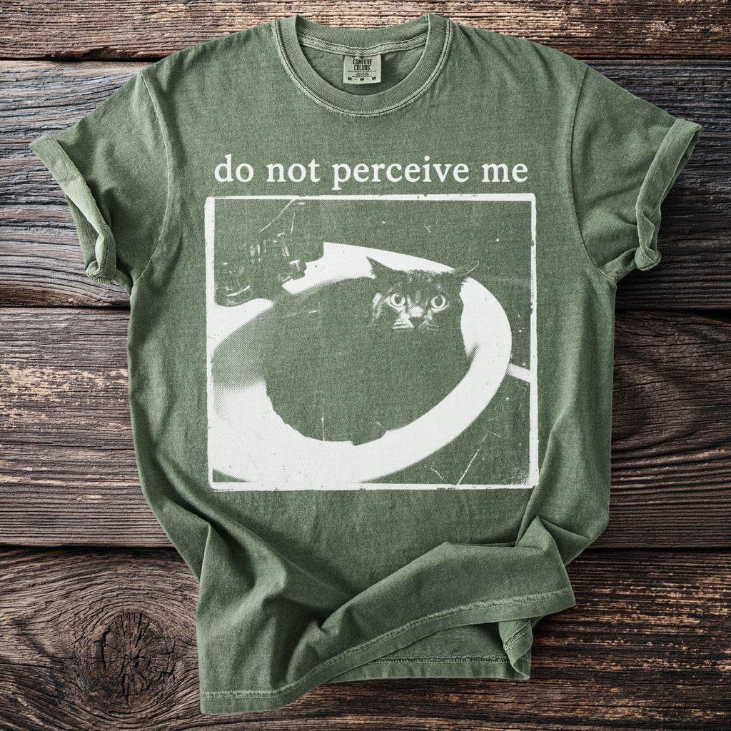 Green t-shirt with distressed print of a cat in a sink and "do not perceive me".