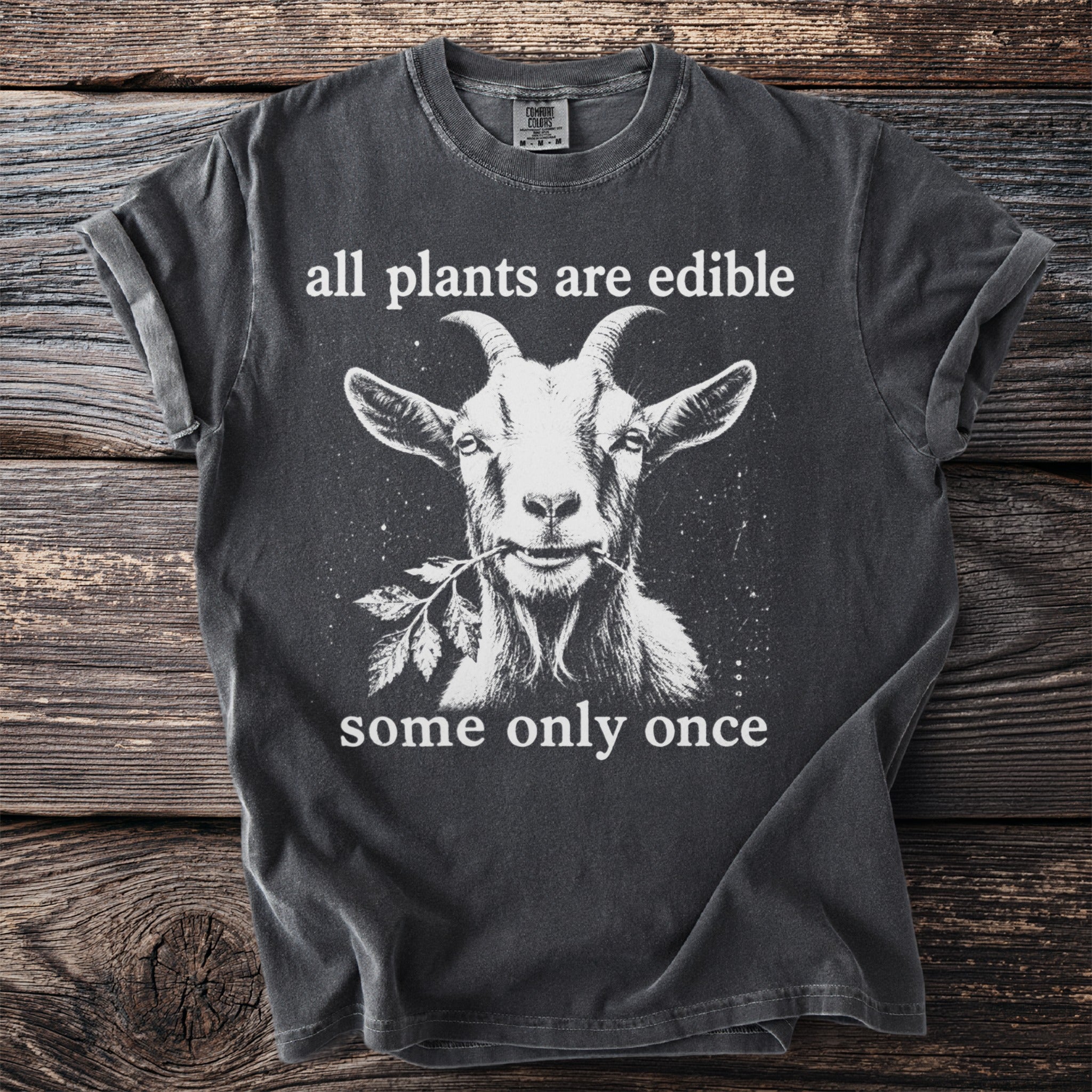 Grey t-shirt with a goat eating a plant and text "all plants are edible some only once".