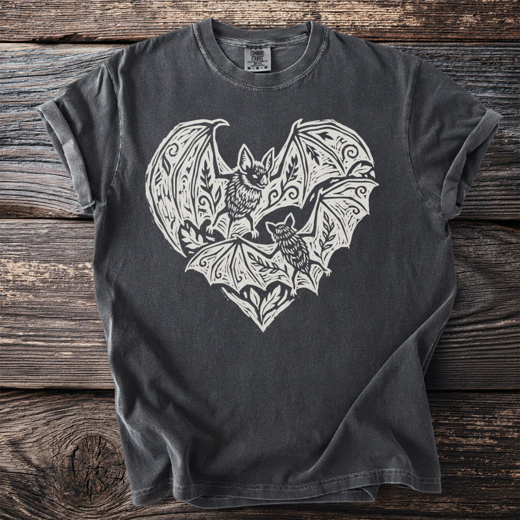 Dark gray t-shirt with a white linocut-style print of two bats within a heart shape.