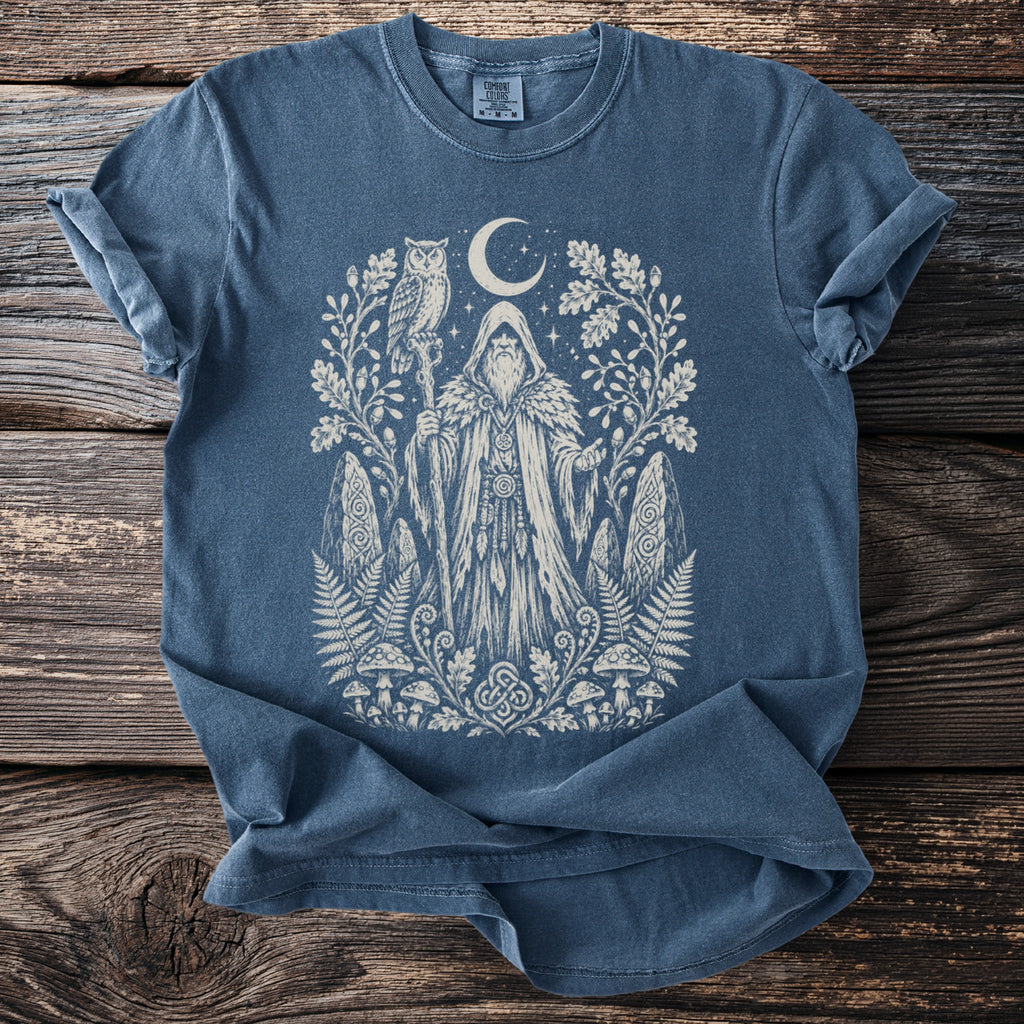 Blue t-shirt with cream print of a wizard with an owl, moon, and forest elements.