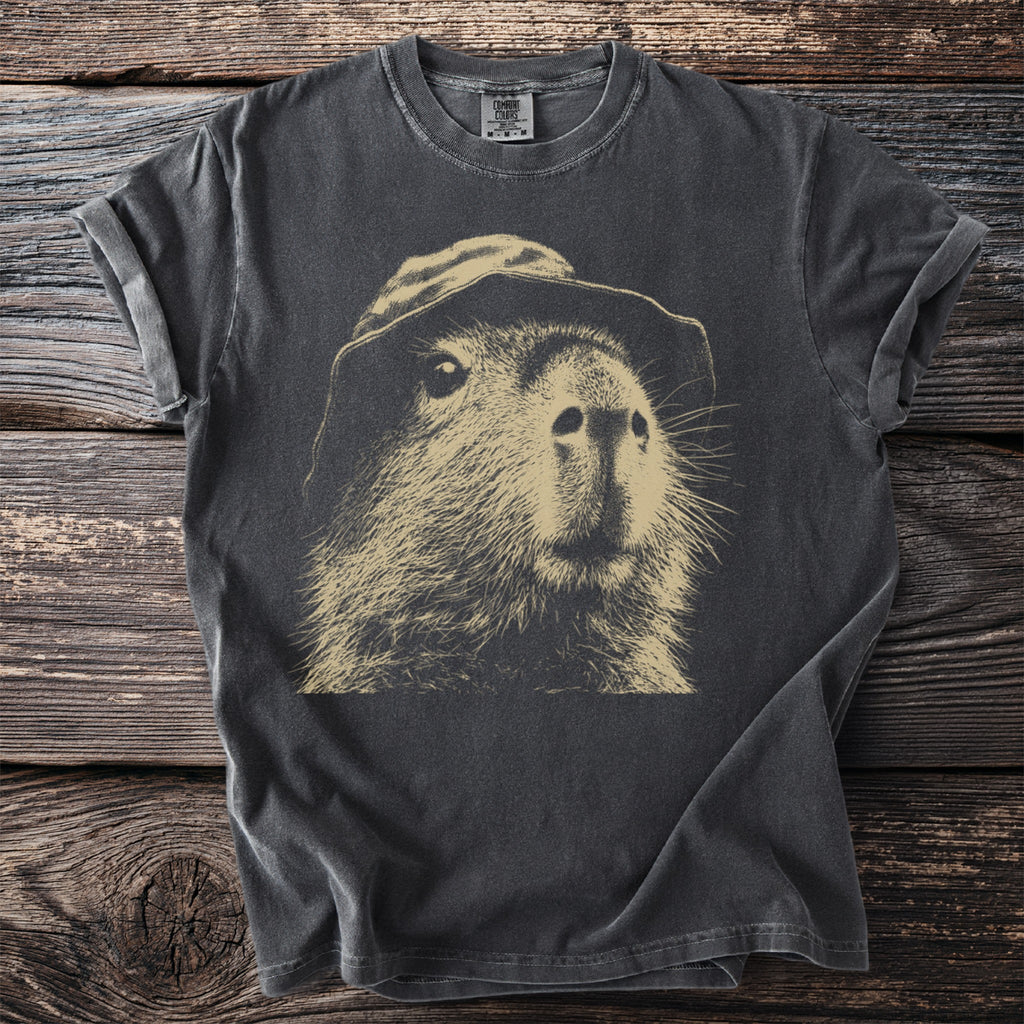 Dark t-shirt with a vintage sketch of a capybara wearing a hat.