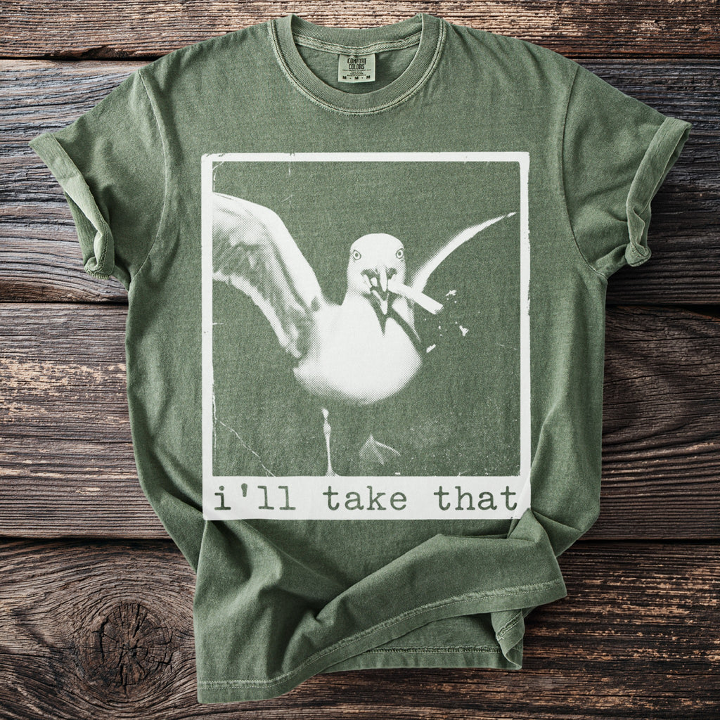 Green t-shirt with a graphic of a seagull holding a cigarette with text "i'll take that".