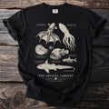 Black t-shirt with vintage illustrations of deep-sea creatures and text "The Abyssal Cabinet".