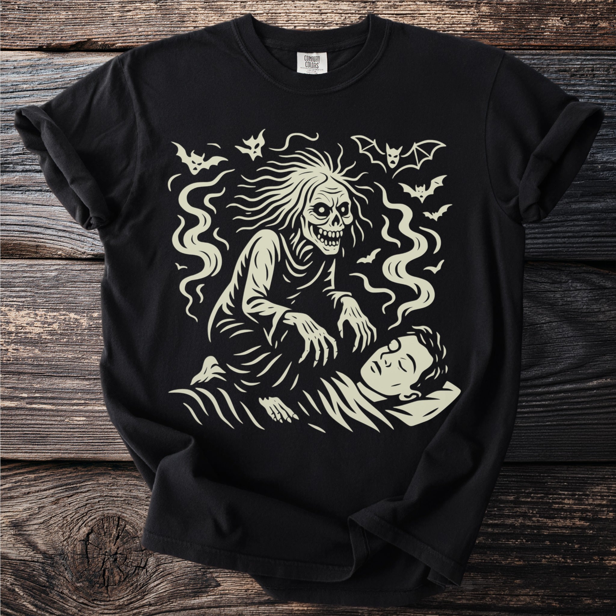 Glow-in-the-dark graphic t-shirt featuring a skeletal creature and bats over a sleeping person.