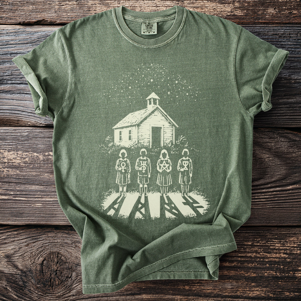 Green t-shirt with a white print of a schoolhouse, starry sky, and four figures with symbols.