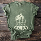 Green t-shirt with a white print of a schoolhouse, starry sky, and four figures with symbols.