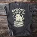 Dark gray t-shirt with "Spooky Book Club" and a cat sitting on books.