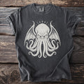 Dark t-shirt with a white graphic of a winged, octopus-like creature.
