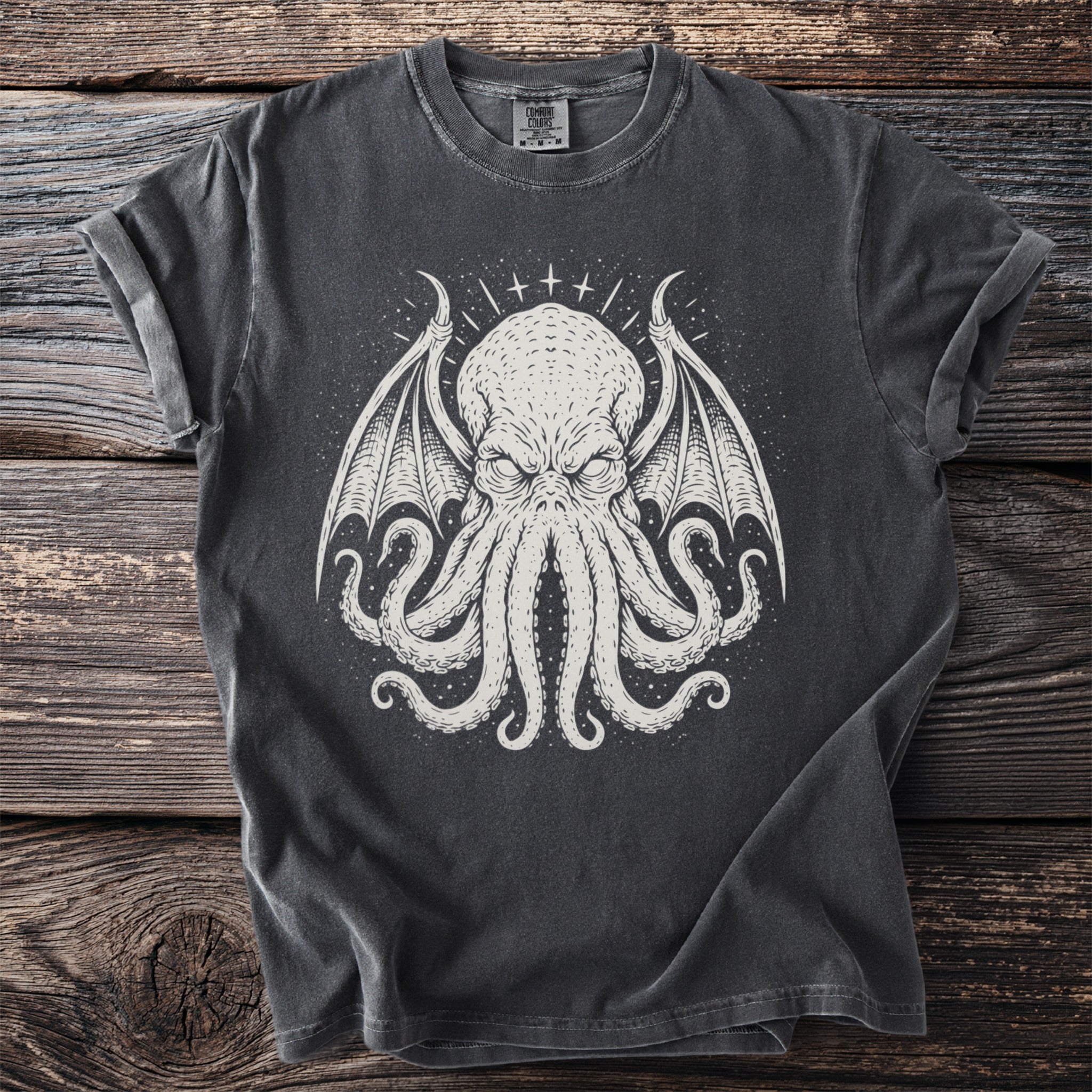Dark t-shirt with a white graphic of a winged, octopus-like creature.