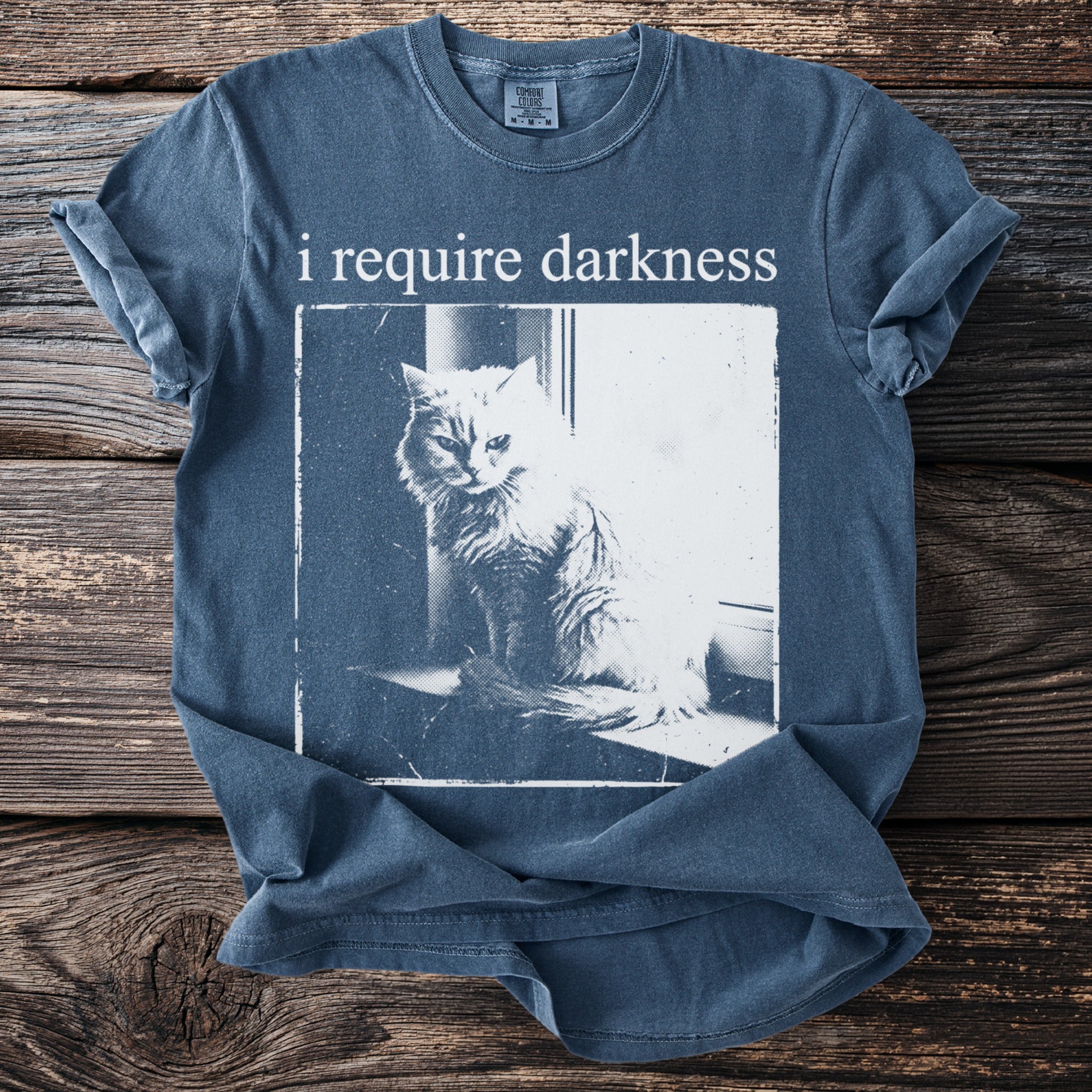 Blue t-shirt with distressed graphic featuring a cat and text "i require darkness".