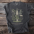 Dark t-shirt with an illustration of poisonous plants titled "The Hedgewitch's Herbarium".