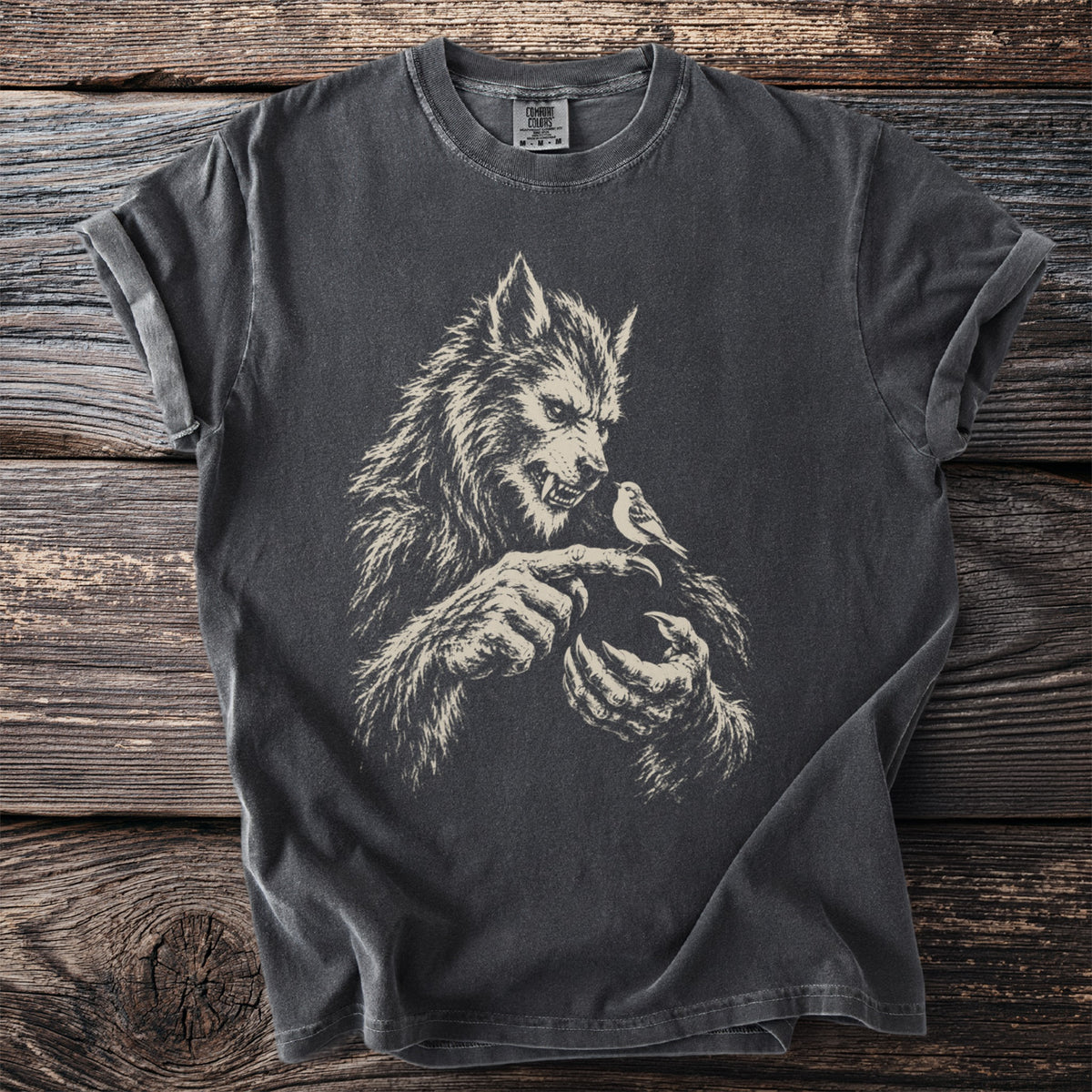 Werewolf with a bird perched on its finger, cream graphic on dark gray t-shirt.
