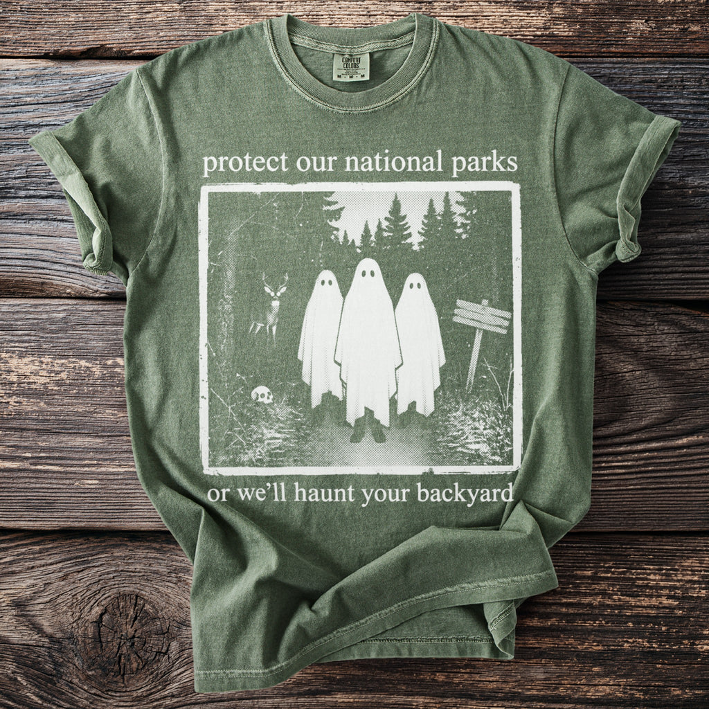 Green t-shirt with text "protect our national parks or we'll haunt your backyard" and a ghost graphic.