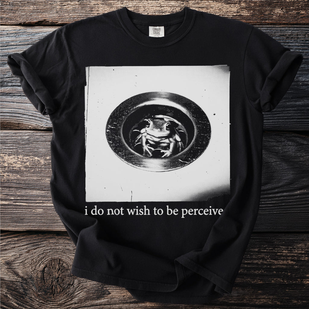 Black t-shirt with a frog in a drain graphic and text "i do not wish to be perceive".