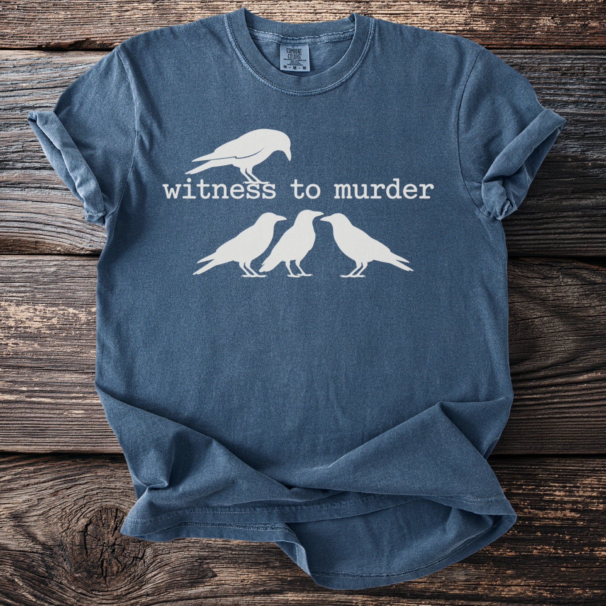 Dark blue t-shirt with white graphic of one crow above three crows and text "witness to murder".