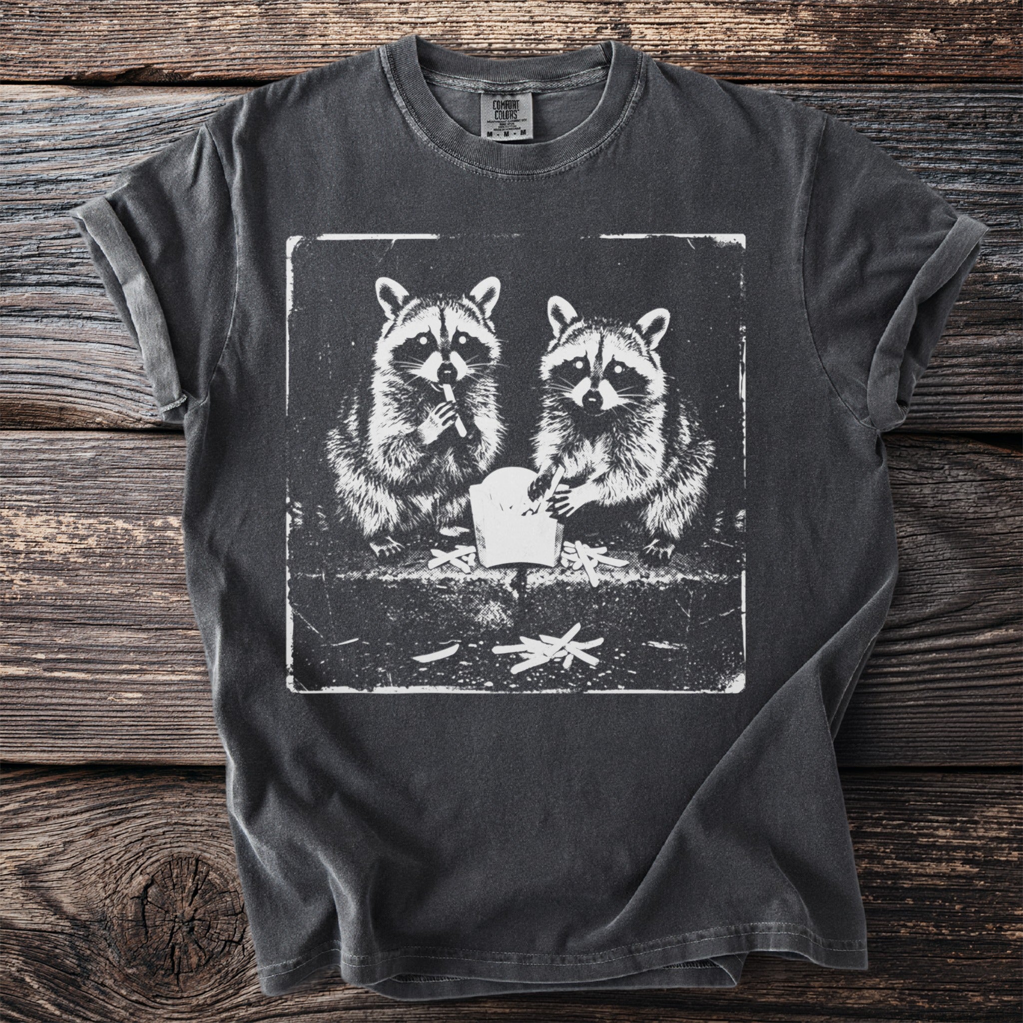 Dark gray t-shirt with a distressed print of two raccoons eating french fries.