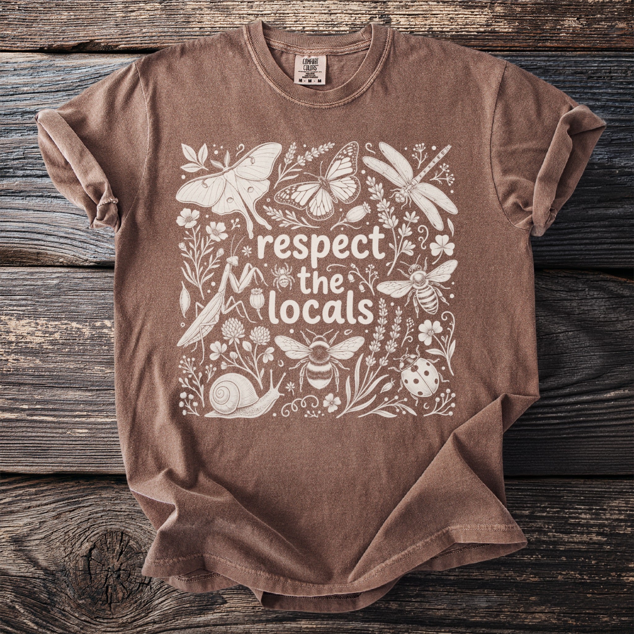 Brown t-shirt with a white floral design and the text "respect the locals" and insects.