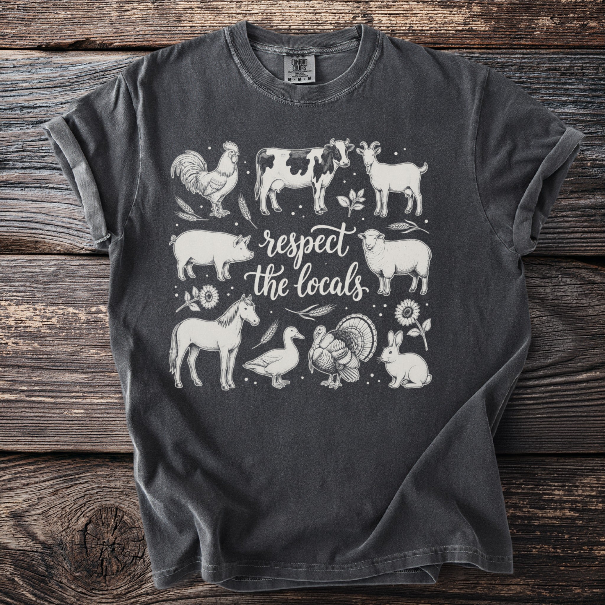 Dark grey t-shirt with line drawing of farm animals and the text "respect the locals".