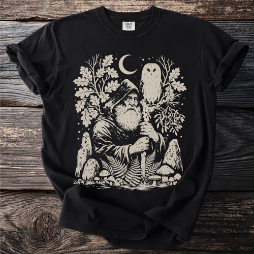 Black t-shirt with image of wizard, owl, moon, mushrooms, and ferns.
