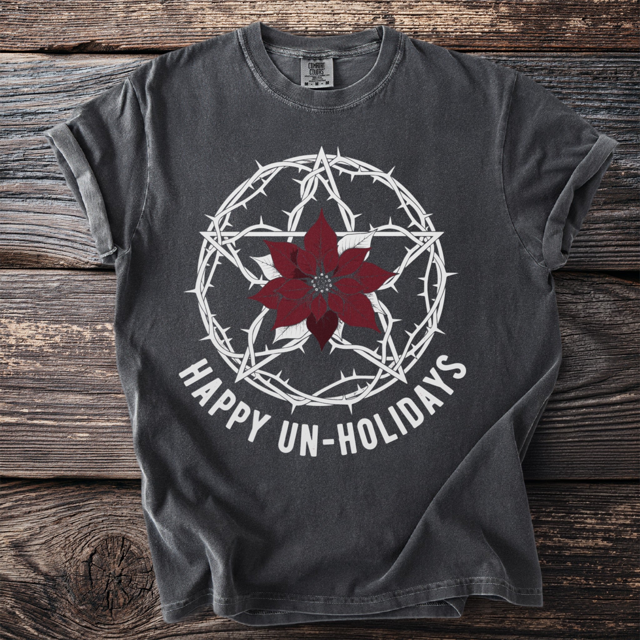 Dark gray t-shirt with white pentagram, poinsettia, and text "HAPPY UN-HOLIDAYS".