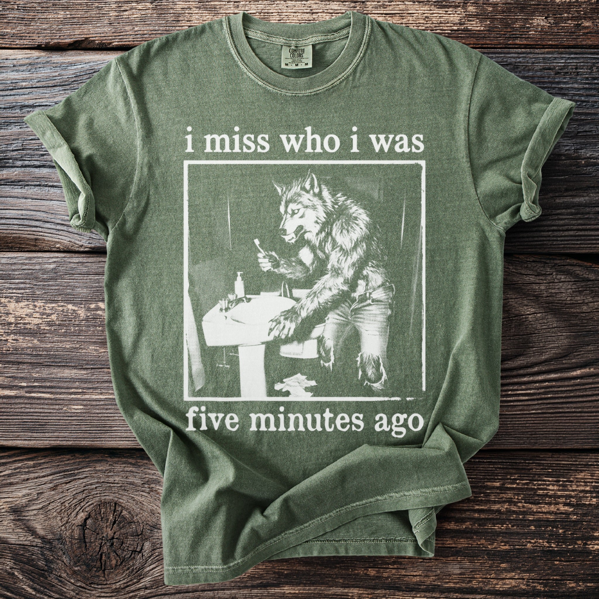 Green t-shirt with werewolf at sink and text "i miss who i was five minutes ago".