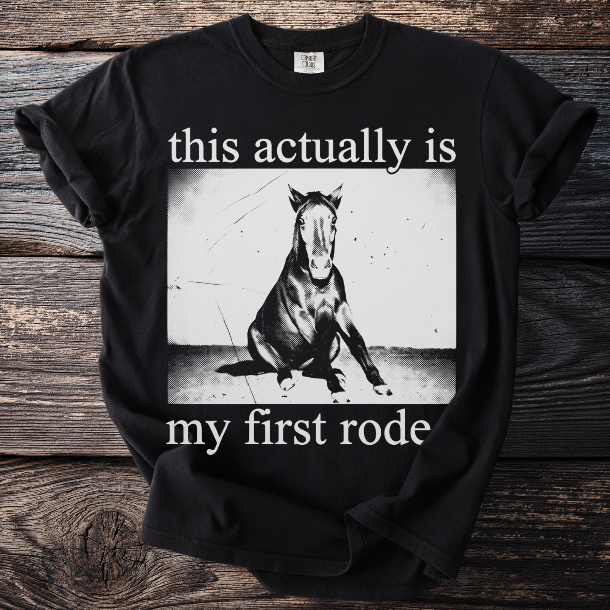Black t-shirt with a distressed image of a horse and text this actually is my first rode.