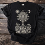 Black t-shirt with pagan sun, moon, and candle-holding figures in a celestial ritual.
