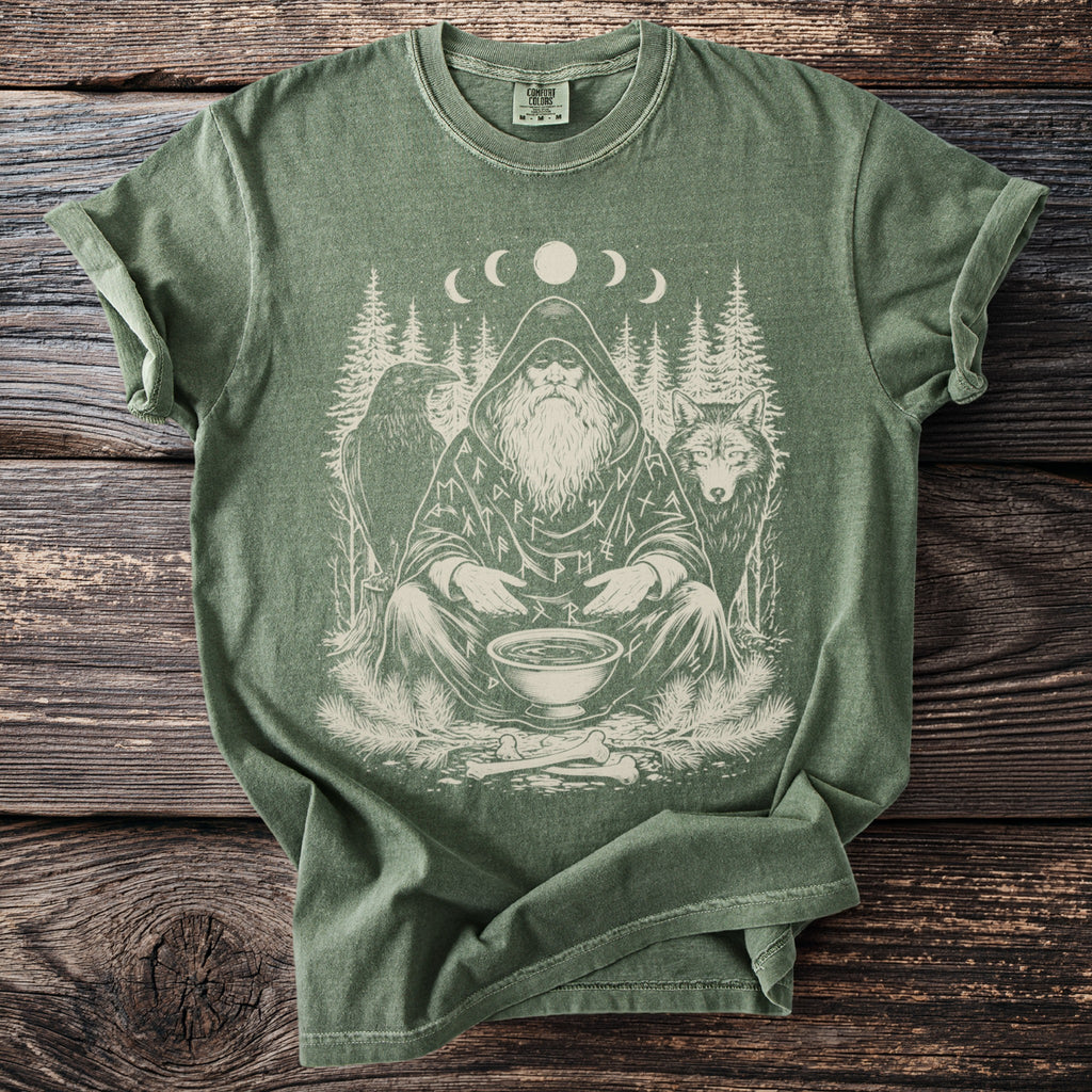 Green t-shirt with a print of a bearded figure, raven, wolf, and moon phases.