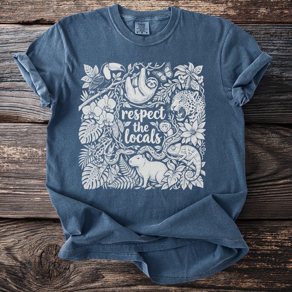 Blue t-shirt with white graphic of rainforest animals and text "respect the locals".