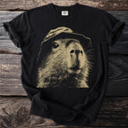 Black t-shirt with a beige illustration of a capybara wearing a hat.