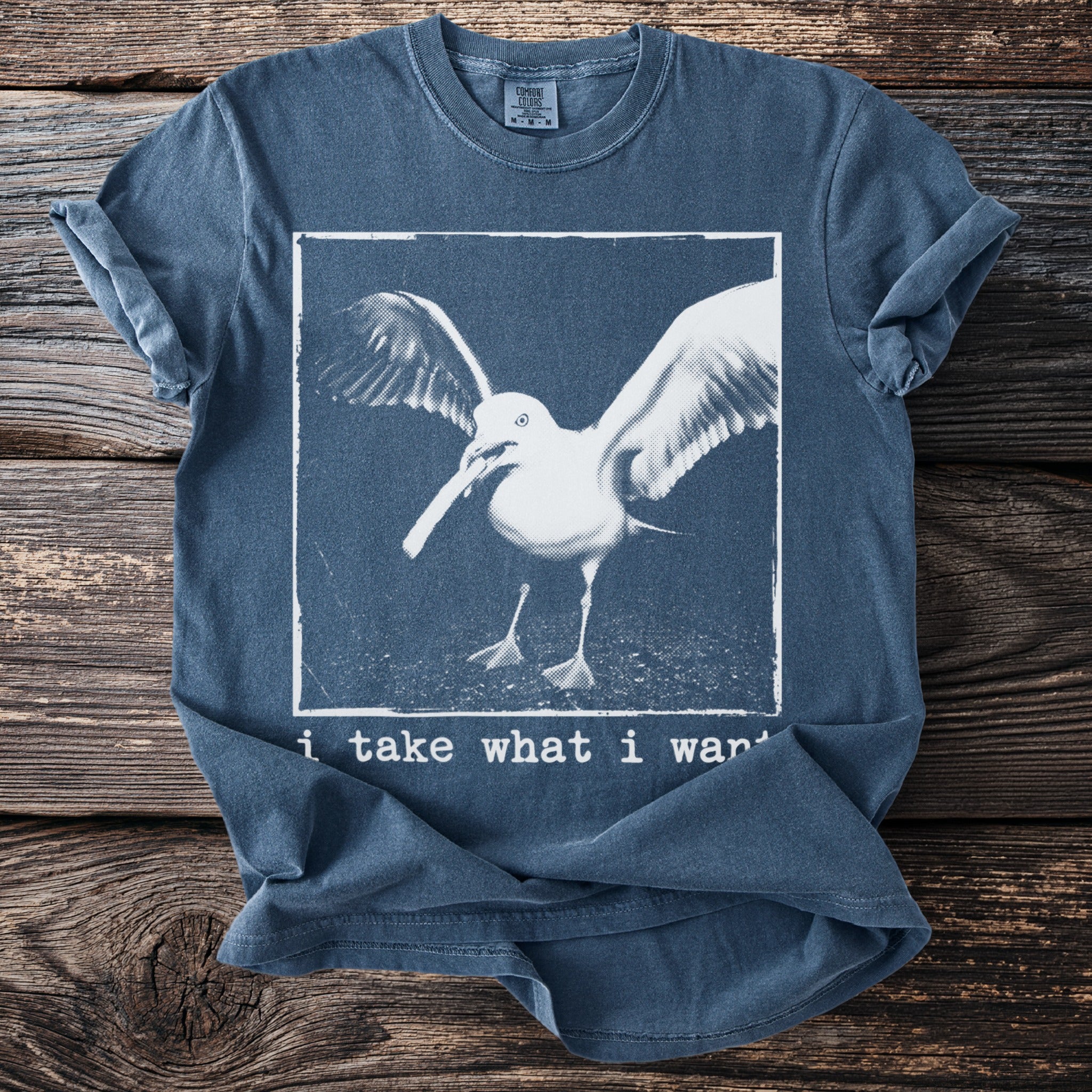 Blue t-shirt with a seagull image and text "i take what i want".