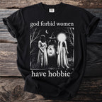 Black t-shirt with "god forbid women have hobbies" and three figures in a forest.