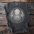 Dark grey t-shirt with a tentacled creature and occult symbols on a rustic wooden background.