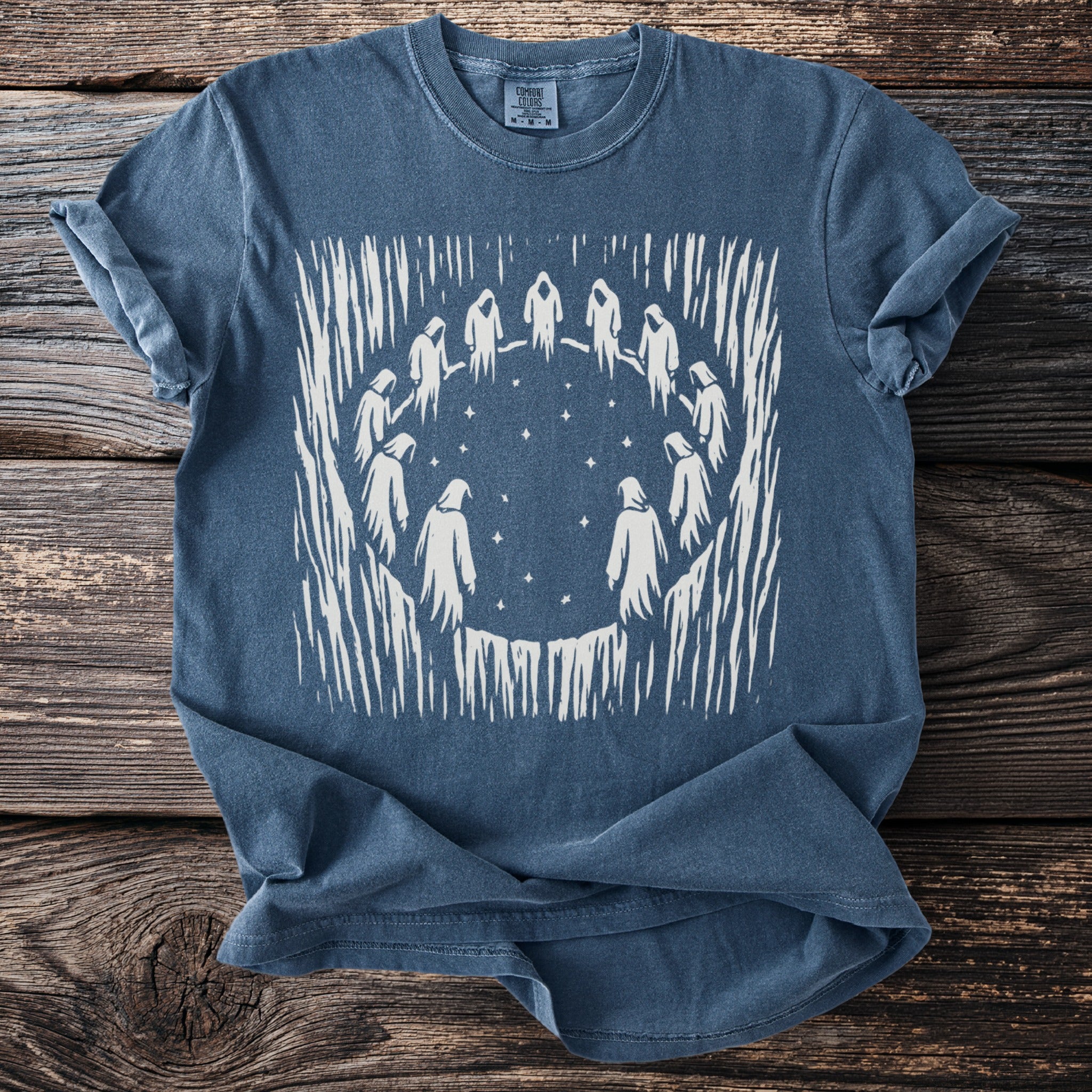 Blue t-shirt with white graphic of figures in a circle under stars.
