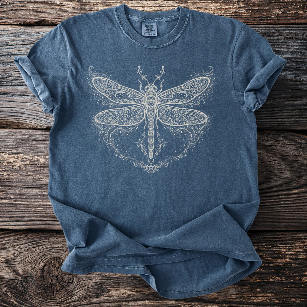 Blue t-shirt with white dragonfly and celestial graphic including stars and crescent moons.
