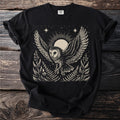 Black t-shirt with a cream linocut-style owl flying against a radiant sun and night sky.