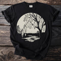 Black t-shirt with a nature scene featuring a tree and river at sunset.
