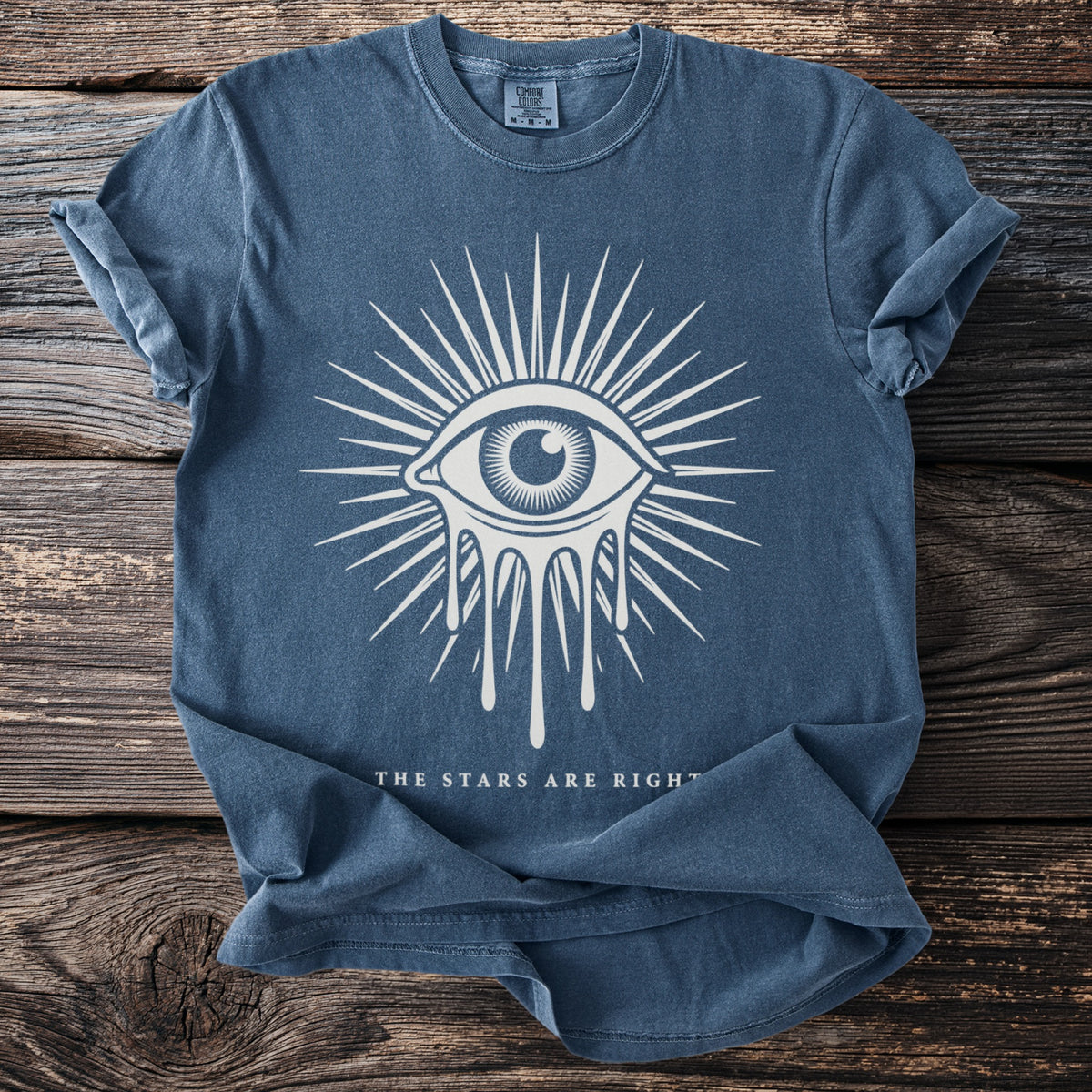 Blue t-shirt with a dripping eye design and text "THE STARS ARE RIGHT".