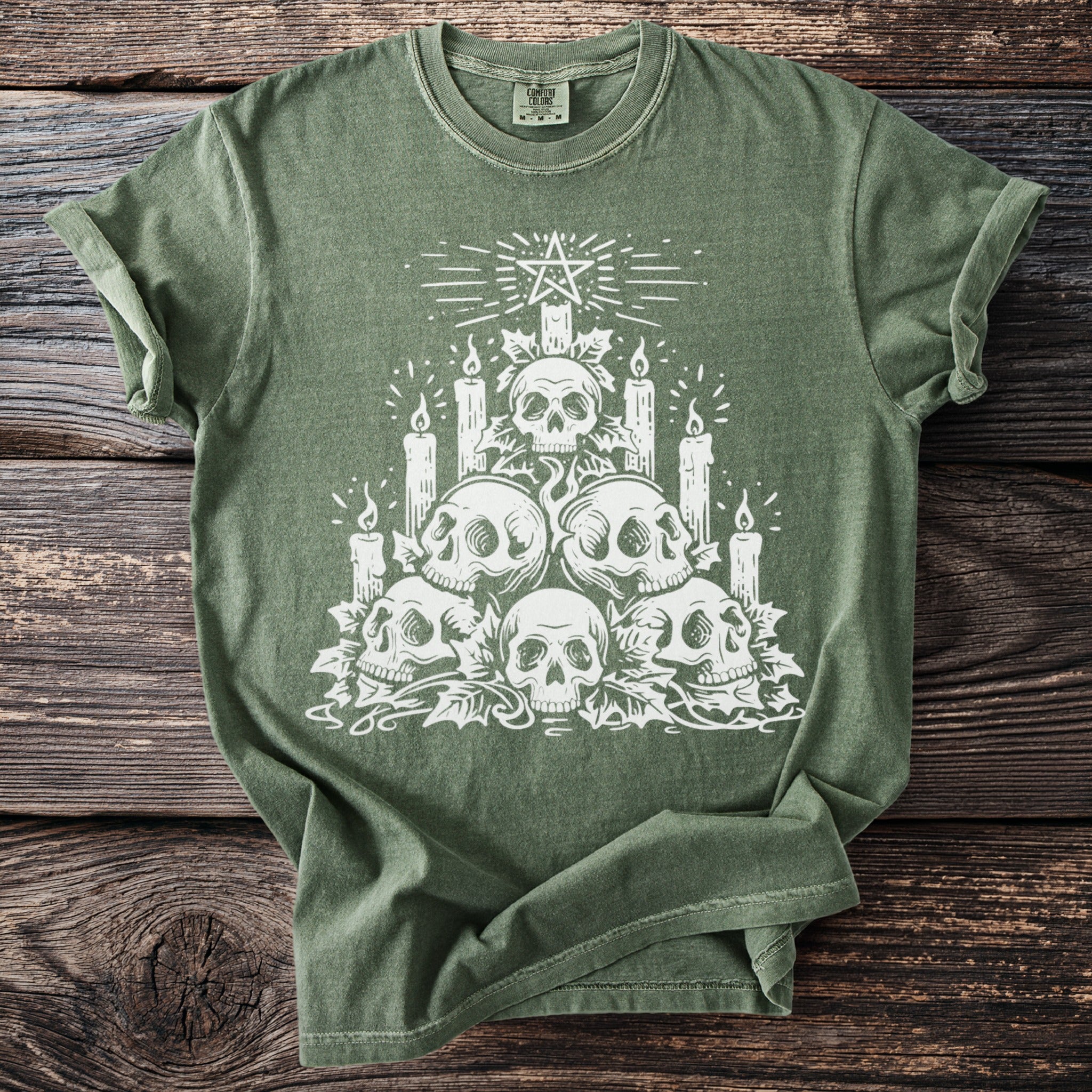 Green t-shirt with a white graphic of skulls, candles, and a pentagram.