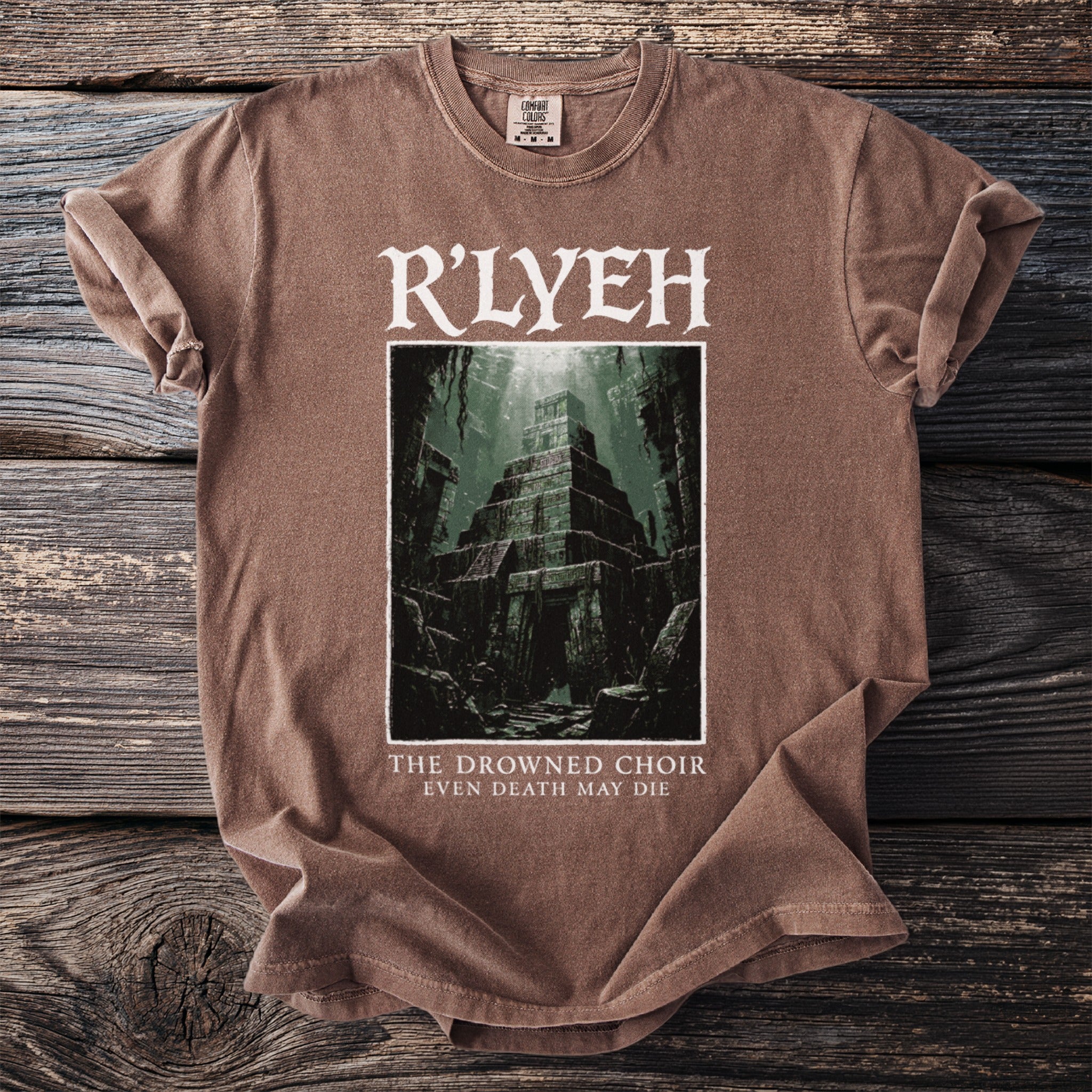 Brown t-shirt with "R'LYEH" above an image of a sunken temple and text "THE DROWNED CHOIR EVEN DEATH MAY DIE".