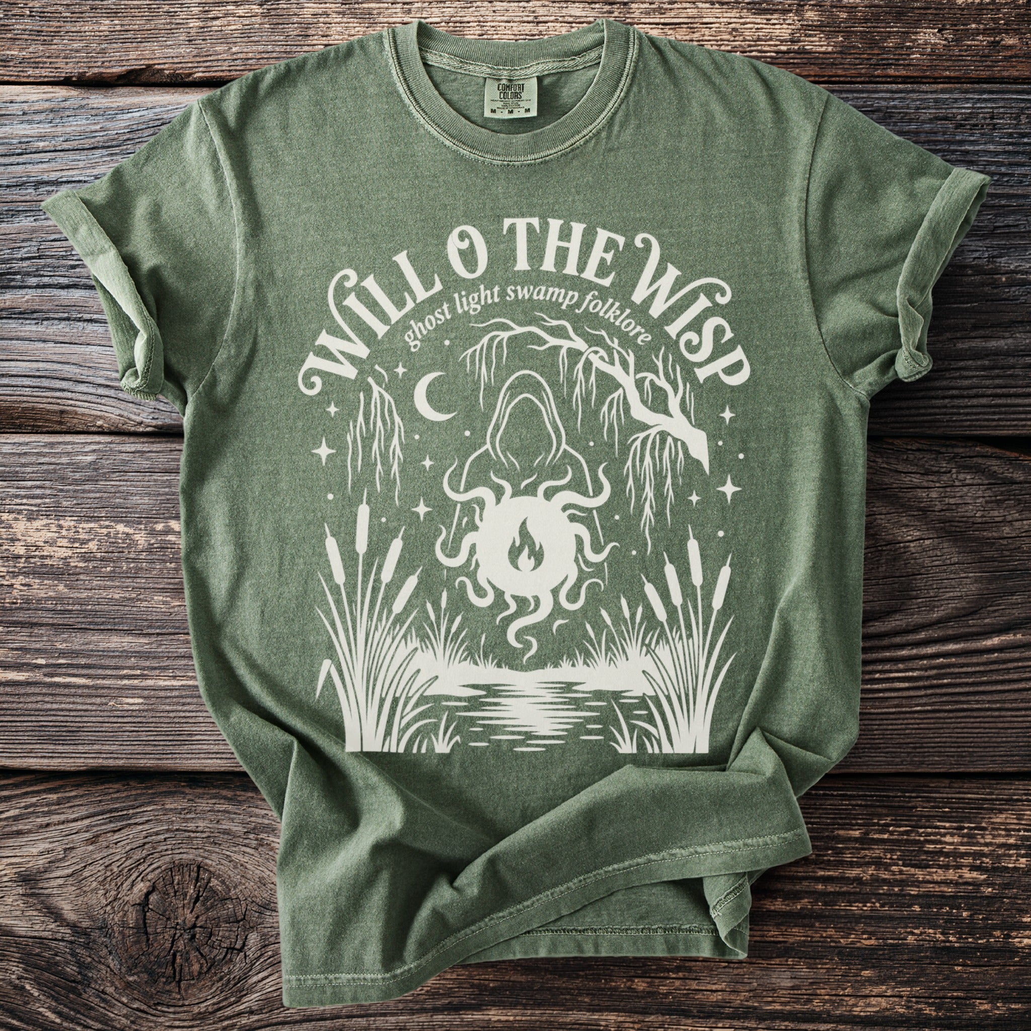 Green t-shirt with "Will o' the Wisp ghost light swamp folklore" graphic.