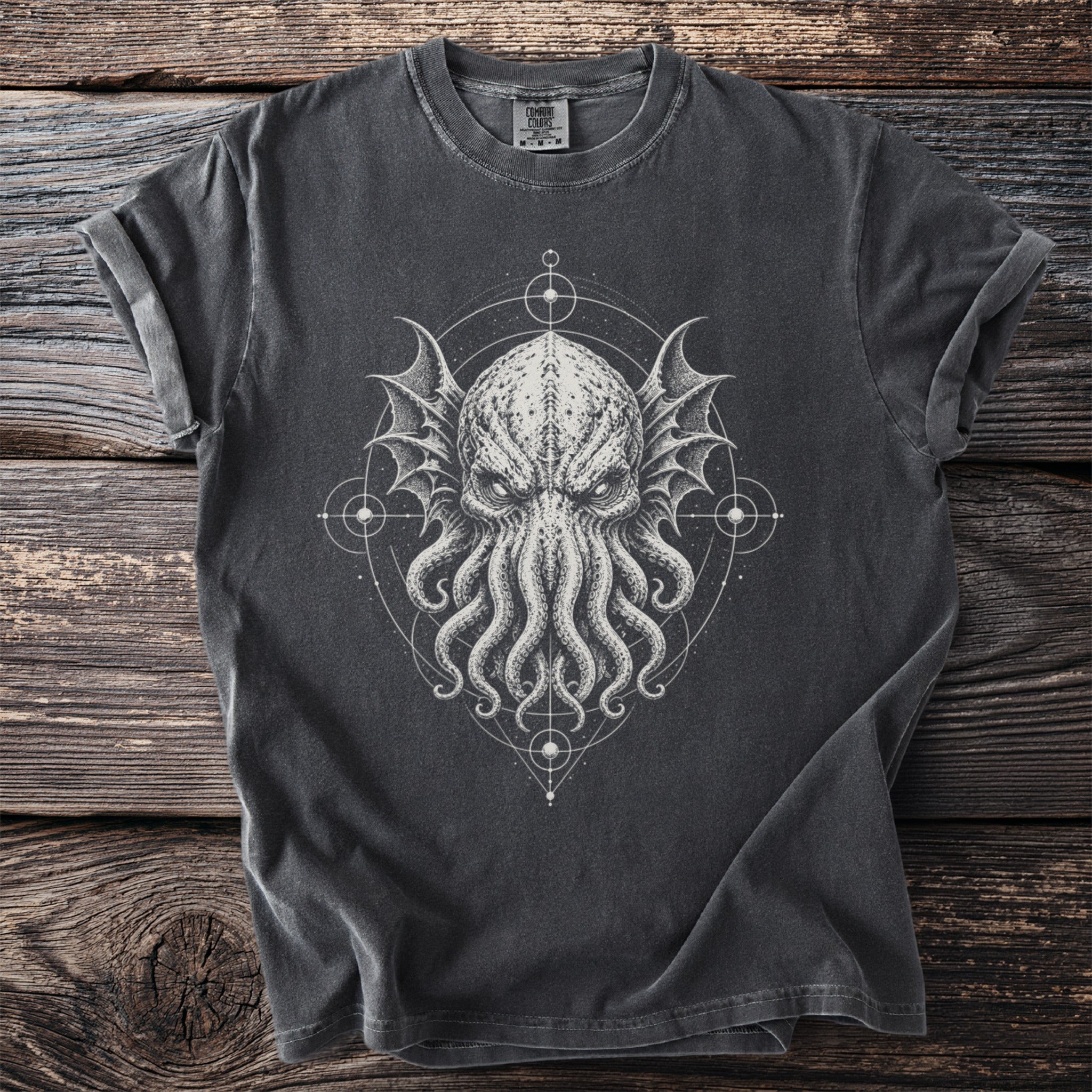 Dark t-shirt with tentacled creature graphic and geometric patterns on wooden background.