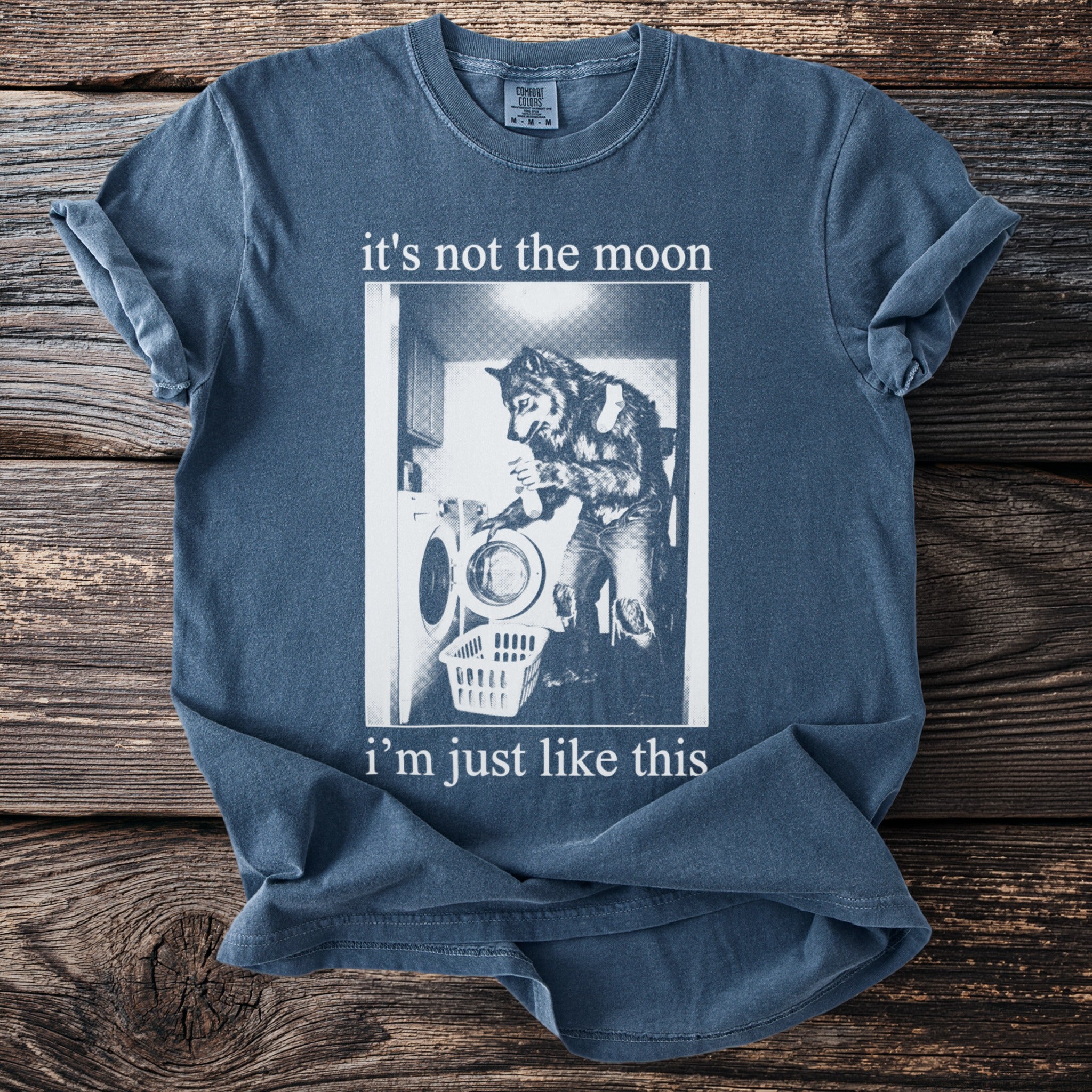 Blue t-shirt with text "it's not the moon i'm just like this" and a graphic.