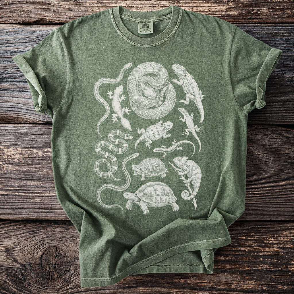 Green t-shirt with charcoal sketch-style print of various reptiles and amphibians.