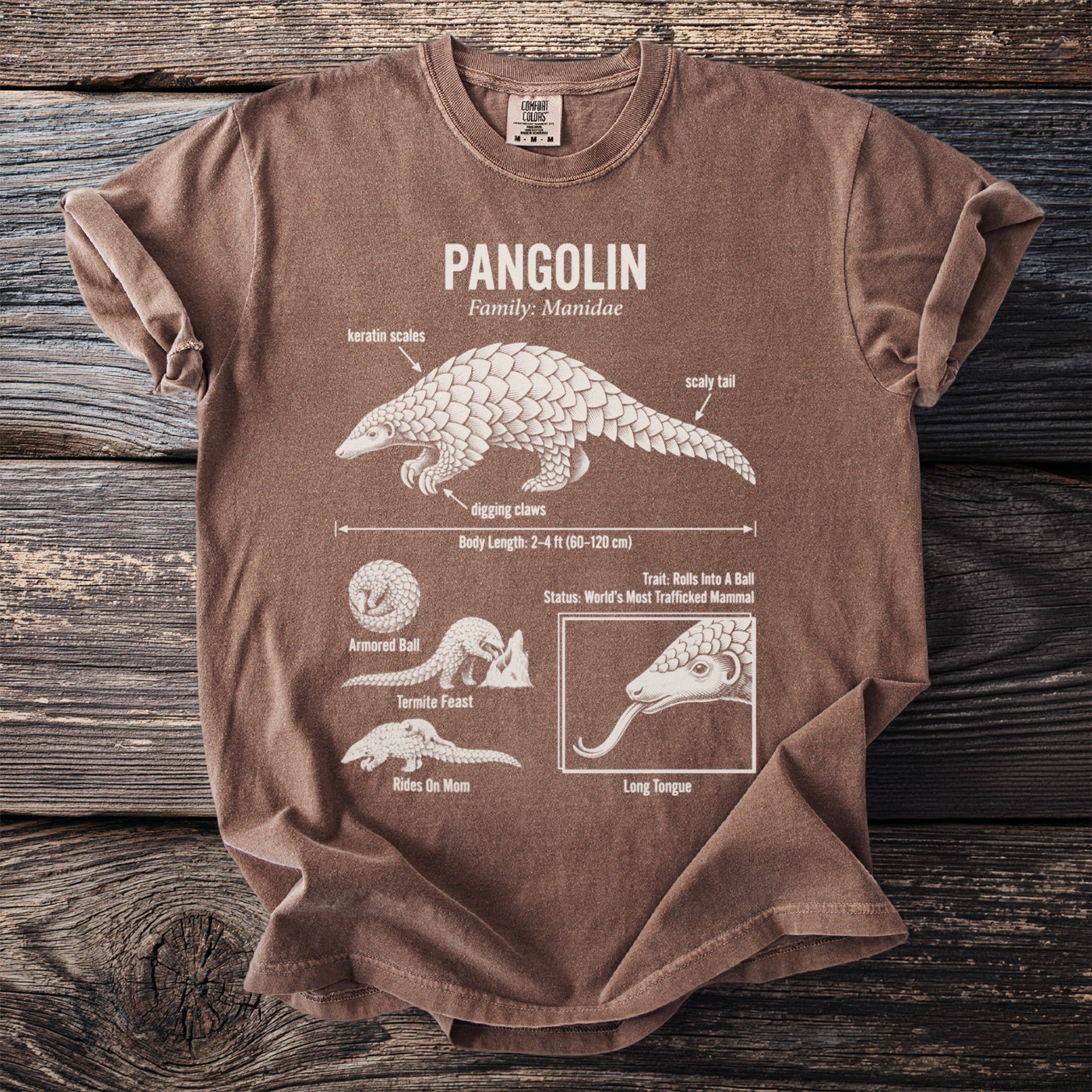 Brown t-shirt with diagram of a pangolin, labeled with its features and habits.